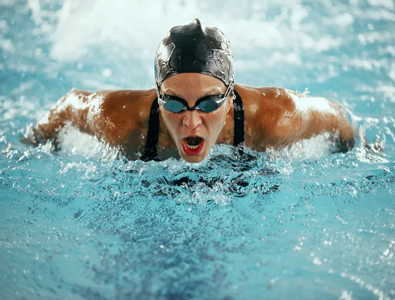 A woman swimming racing and swimming the butterfly