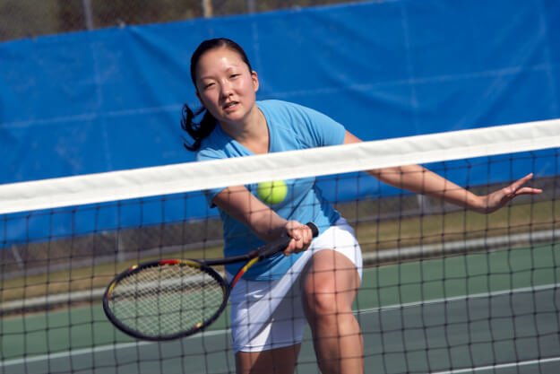 Nycshooter, pexels Female athlete playing tennis about to hit a shot at the net